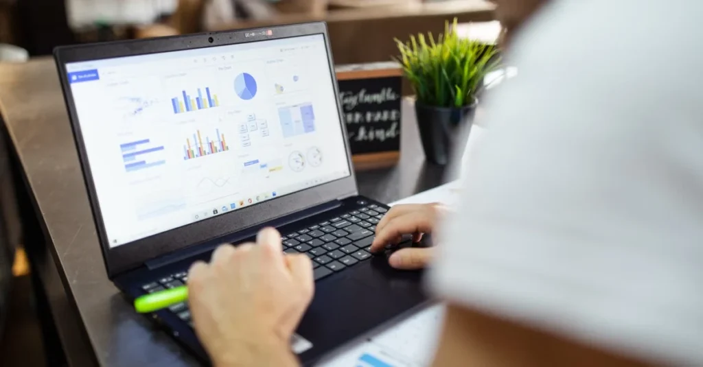 Professional analyzing data dashboards and grin alternatives on laptop screen at office desk.